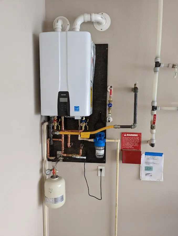 Professional plumber installing copper piping in a West Vincent home